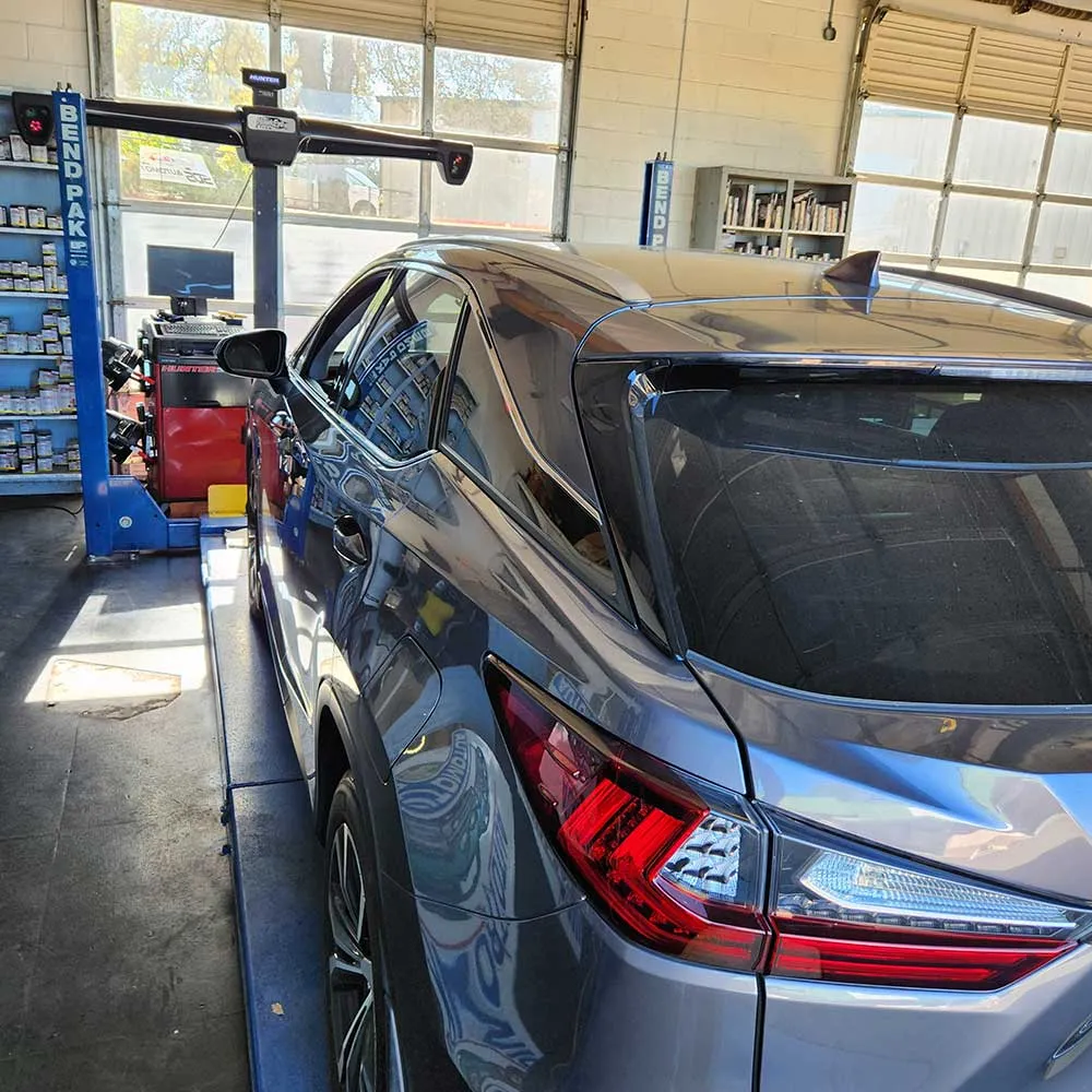 Car in auto repair shop on alignment machine.